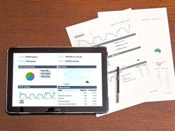 Ipad and papers showing charts and graphs