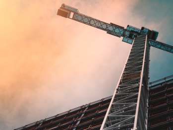 Low angle shot of a crane in front of a building.